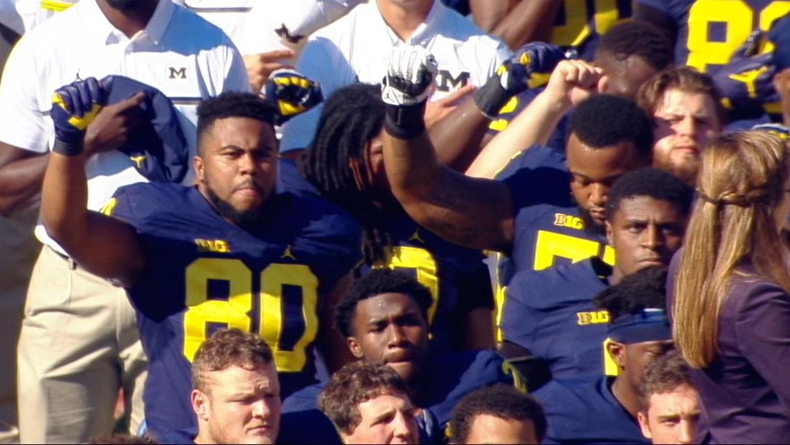 Several Michigan players raise fists during national anthem